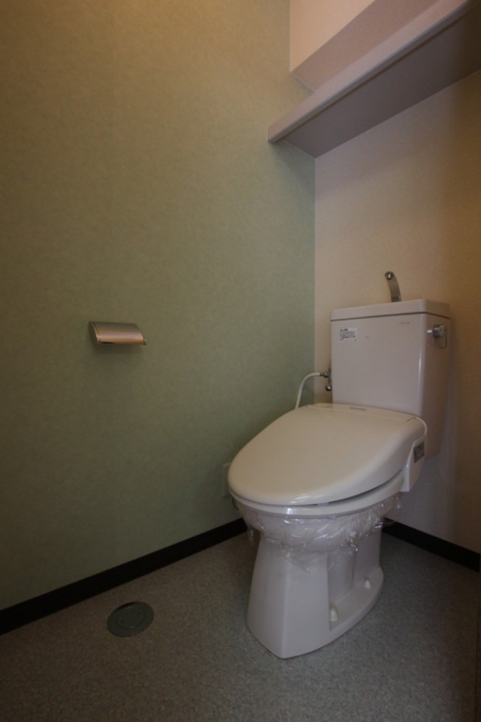 トイレ内は色合いの違ったグリーンの壁紙。