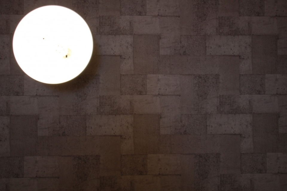 コンクリートブロック調の天井にぶら下がる照明ランプ。