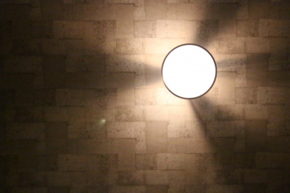 コンクリートブロック調の天井に照明カバーから漏れる光があたる。