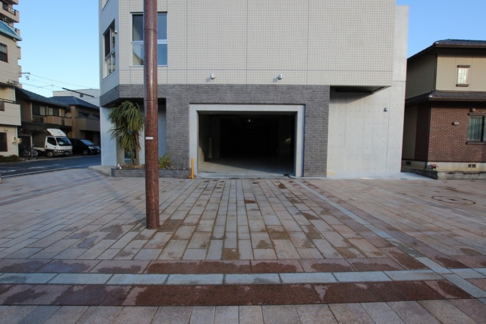 建物西側には平面駐車場の入り口がある。