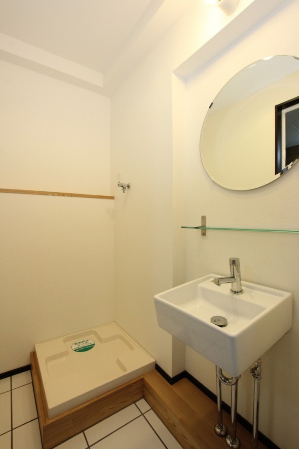 洗面スペース。丸い鏡に四角い洗面台、むき出しの洗面配管がオシャレ