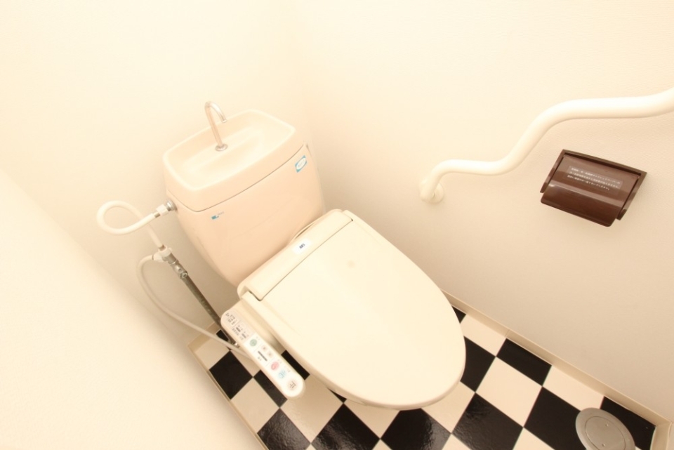 もちろんトイレの床も白×黒。手すりにも遊び心が。