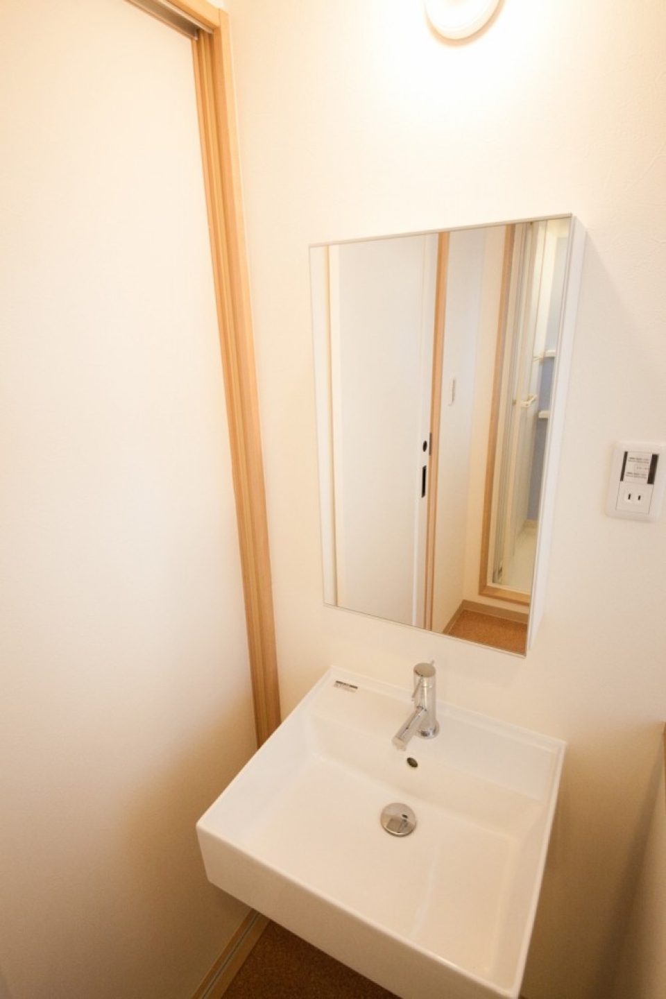 正方形のおしゃれな洗面台。鏡の裏は収納棚に。※写真は302号室