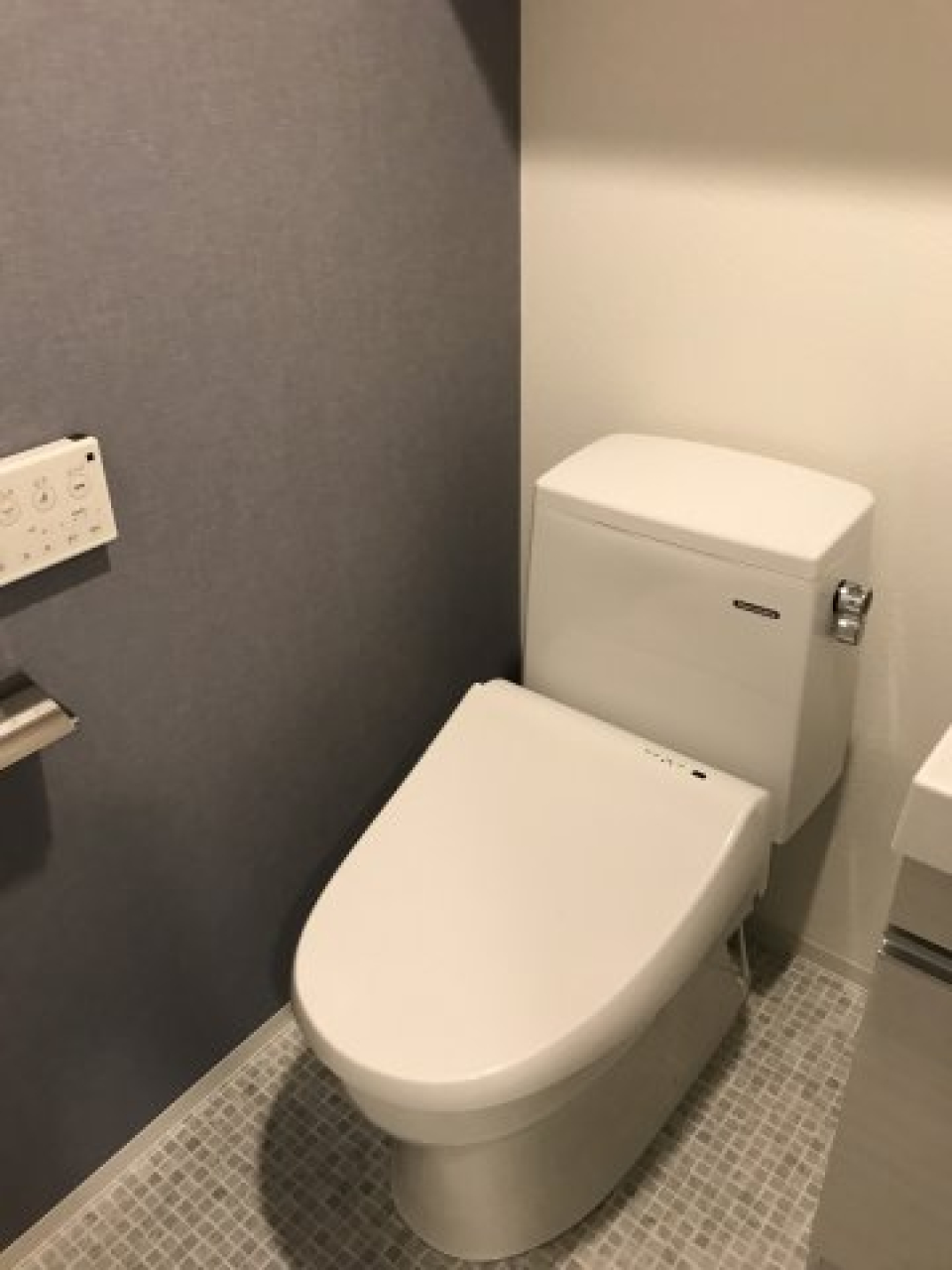 落ち着いたグレーの壁紙が採用されたトイレです。