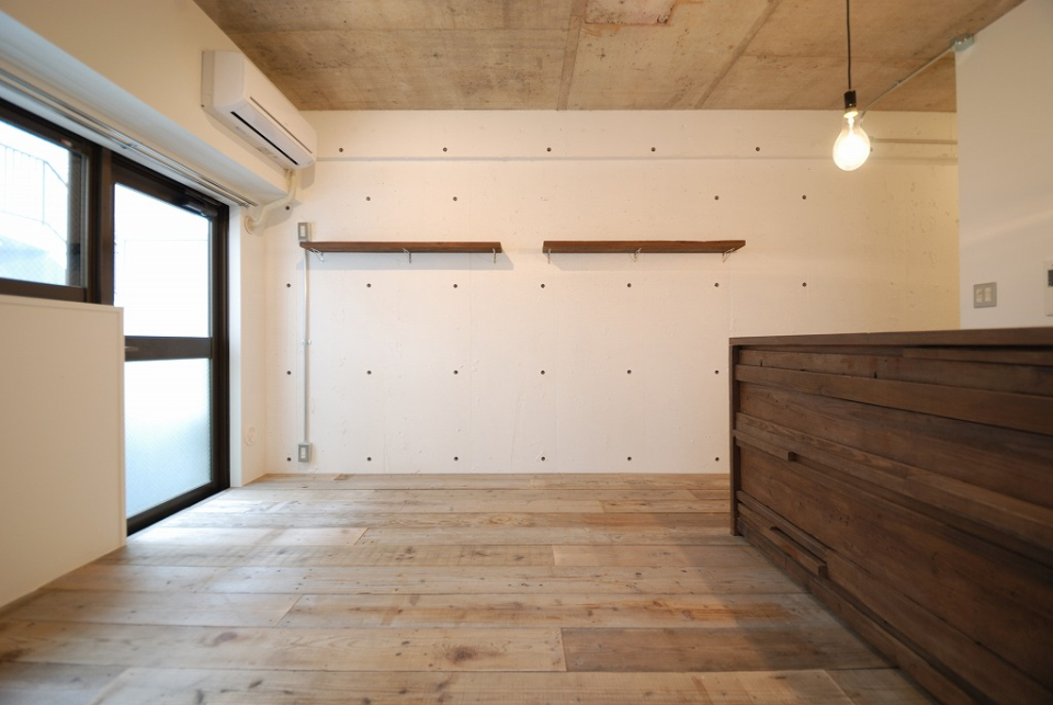 白塗装の壁に造作のアンティーク調の木棚。