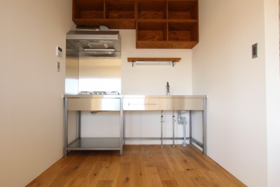 キッチン周り。華奢なステンレス製のキッチンと木製の収納棚が可愛い
