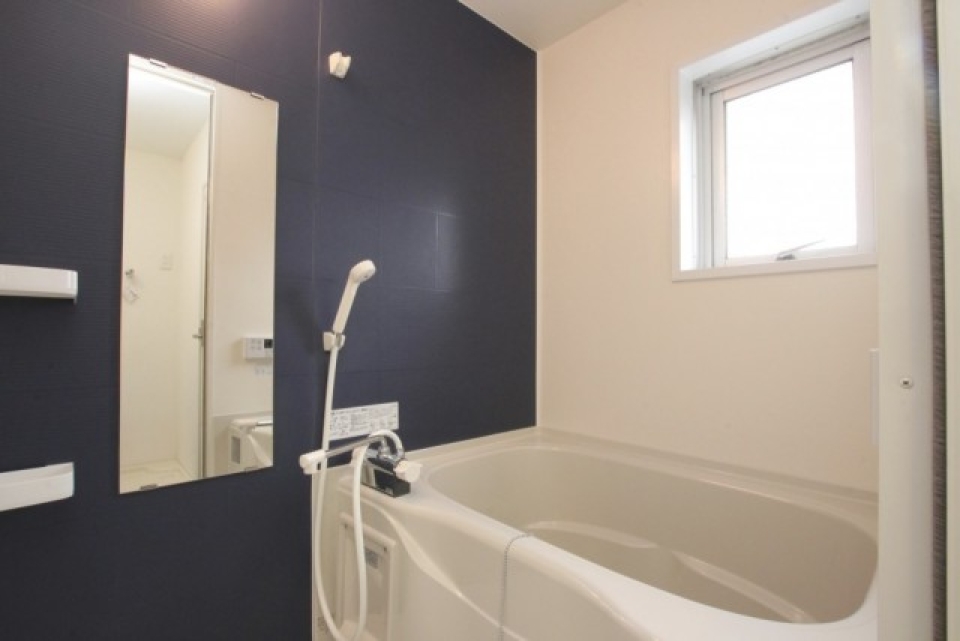 お風呂。こちらも壁の一面のみが紺色になっています。追い炊き・ふろ自動機能付き
