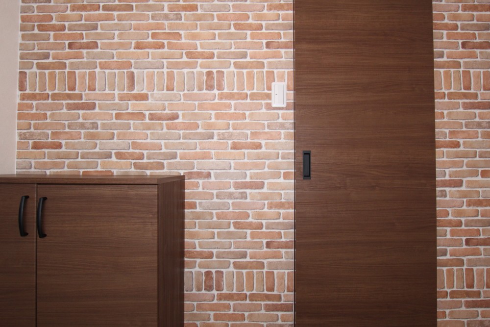 玄関スペースには王道の煉瓦調の壁紙を。