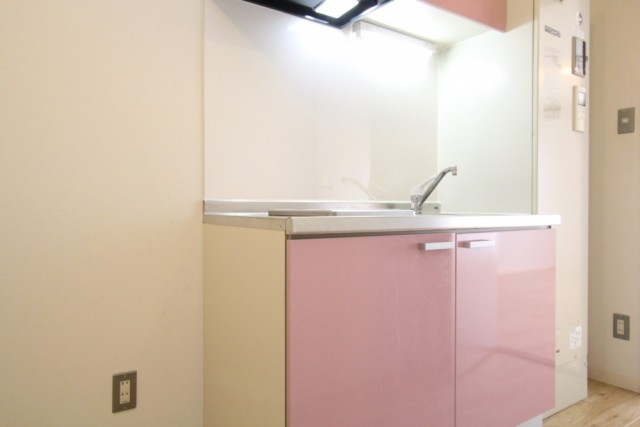ピンクカラーのキッチンにはIHコンロが設置されている。