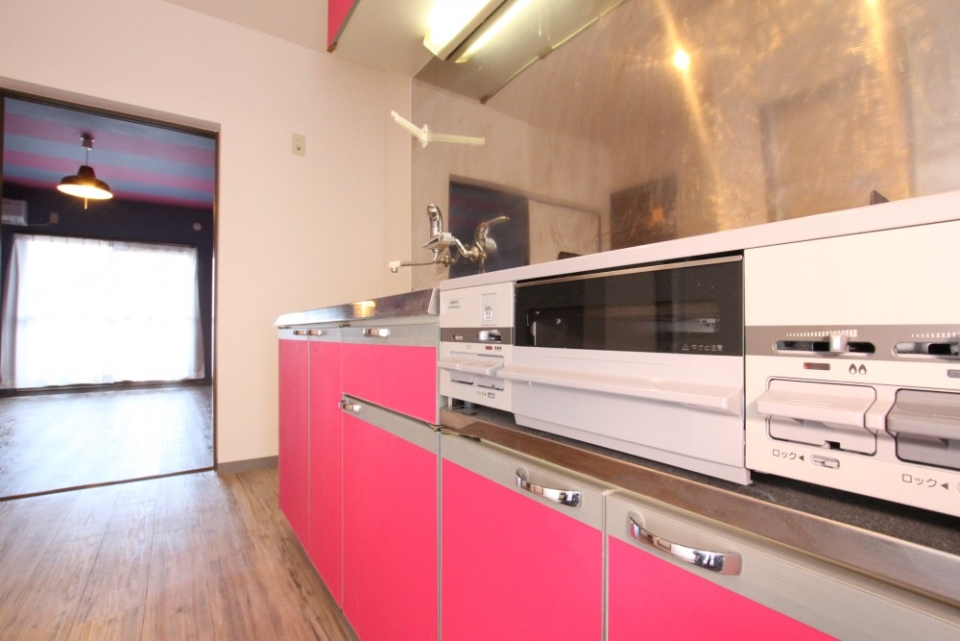 キッチンパネルもピンクで統一されている。