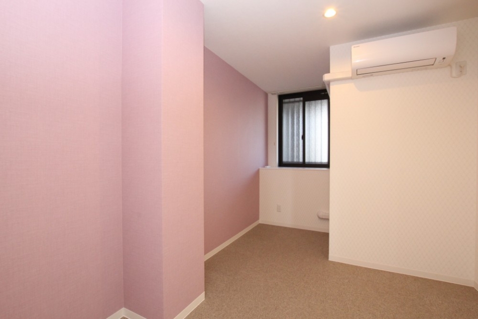 寝室は、柔らかく優しい印象のピンクの壁紙。