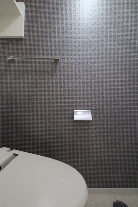 トイレはモザイクタイル調の壁紙を使用。