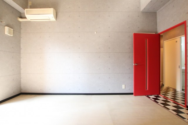 チェックとコンクリートと赤い扉がこのお部屋特徴。
