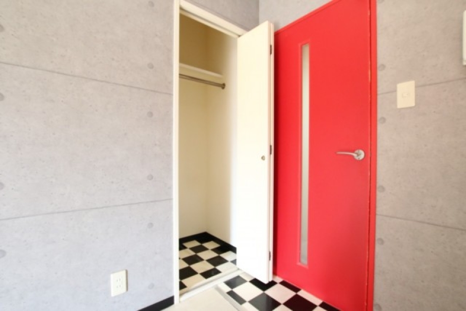 リビングの収納は赤い扉に隠れるようにある。