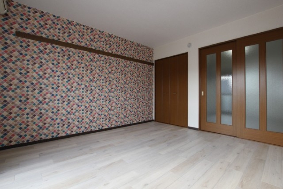 モザイク調の壁紙が使われた洋室は8帖の広さ。