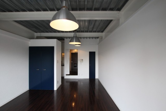 「倉庫風」の味気ない空間に収納扉がブルーが差し色に。