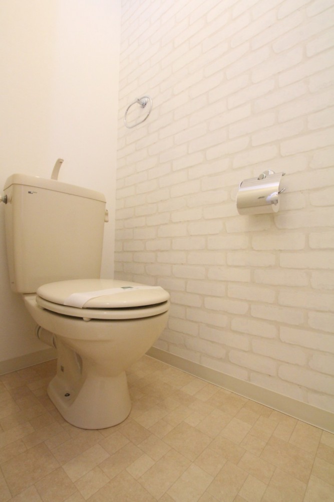 ホワイト煉瓦の壁紙を使用したトイレ。
