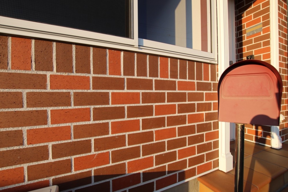 茶色の煉瓦外壁と郵便ポスト。