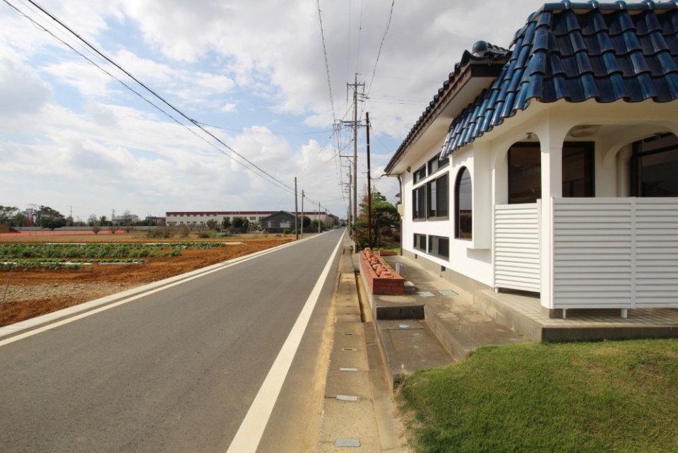 時がゆっくり流れる田舎道沿い。一面の畑が広がる