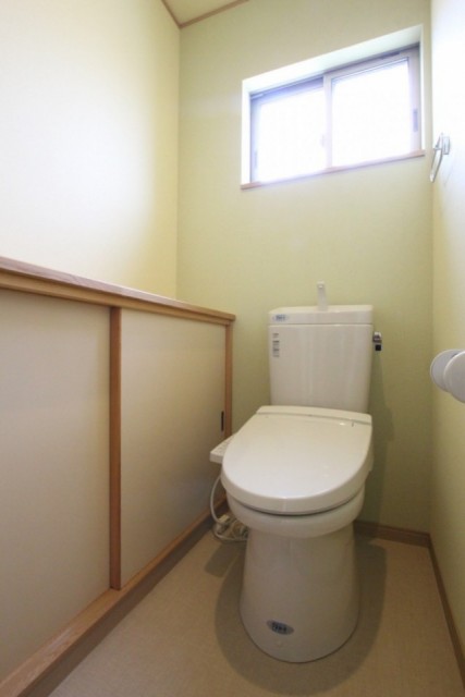 トイレの壁紙は若草色です。トイレの収納スペースもかなり広々！