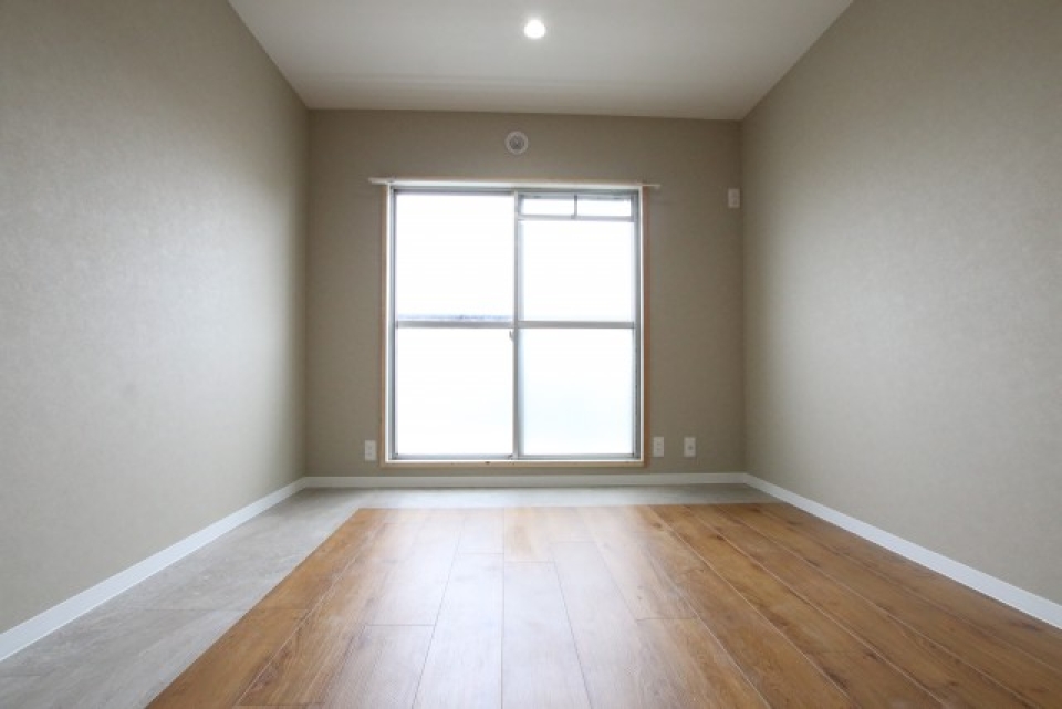 7.8帖の洋室です。木目とモルタルっぽい床の切り替えが印象的。