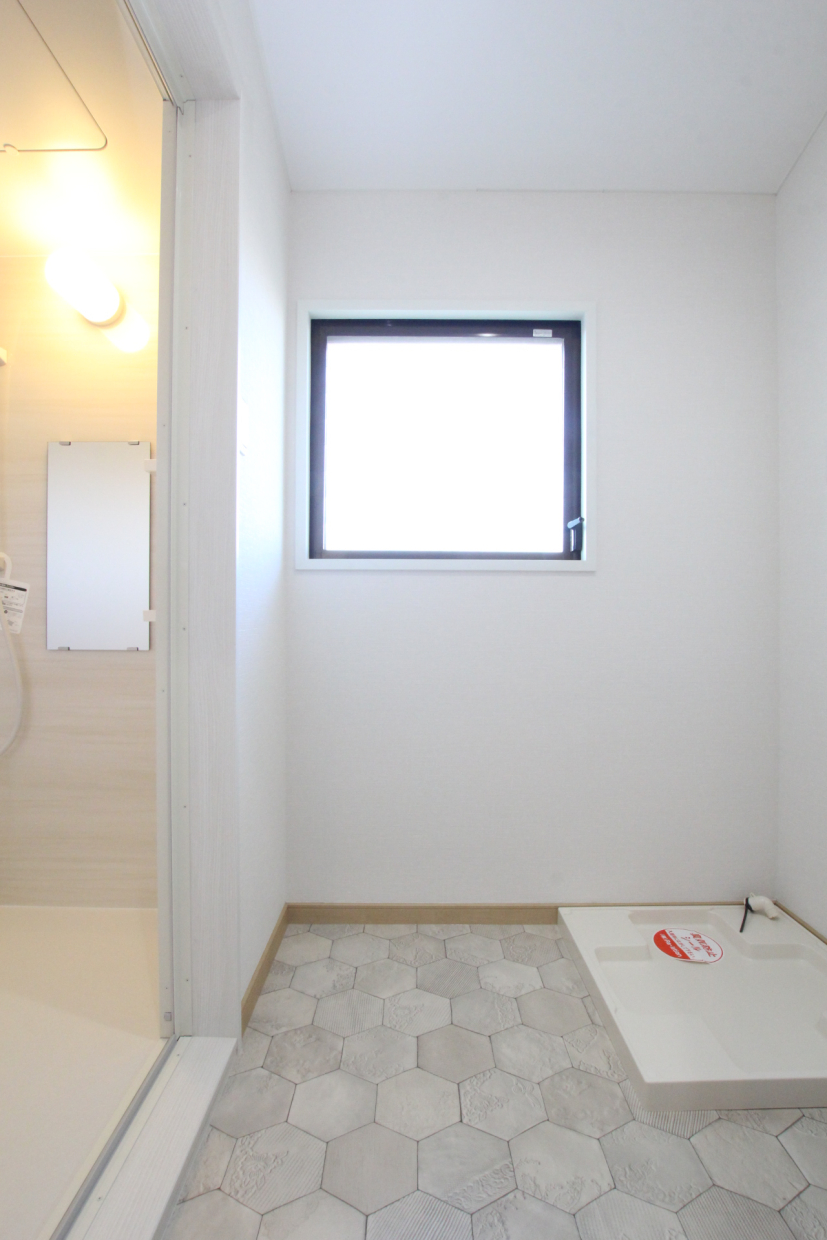 脱衣所は薄いグレーのヘキサゴンタイル風のフロア。大きな換気窓あり