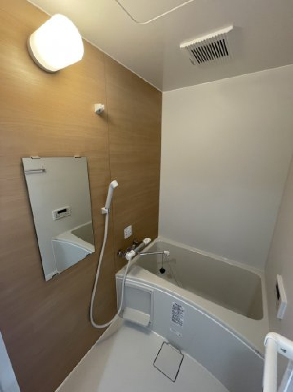ナチュラルな木目調のパネルが採用された浴室。