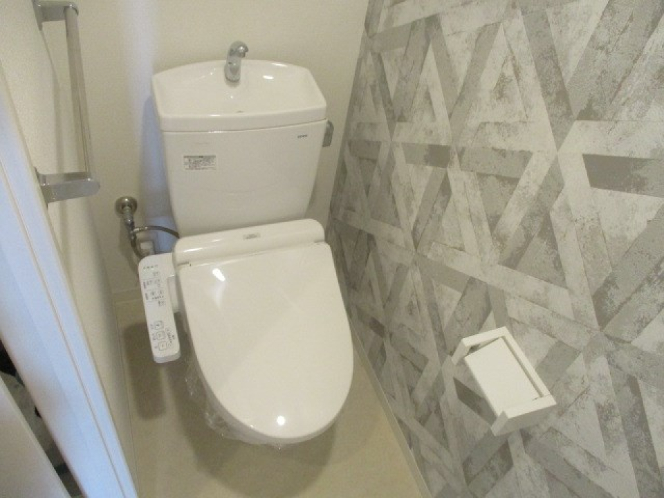 グレーの幾何学模様の壁紙でトイレもおしゃれな印象に。