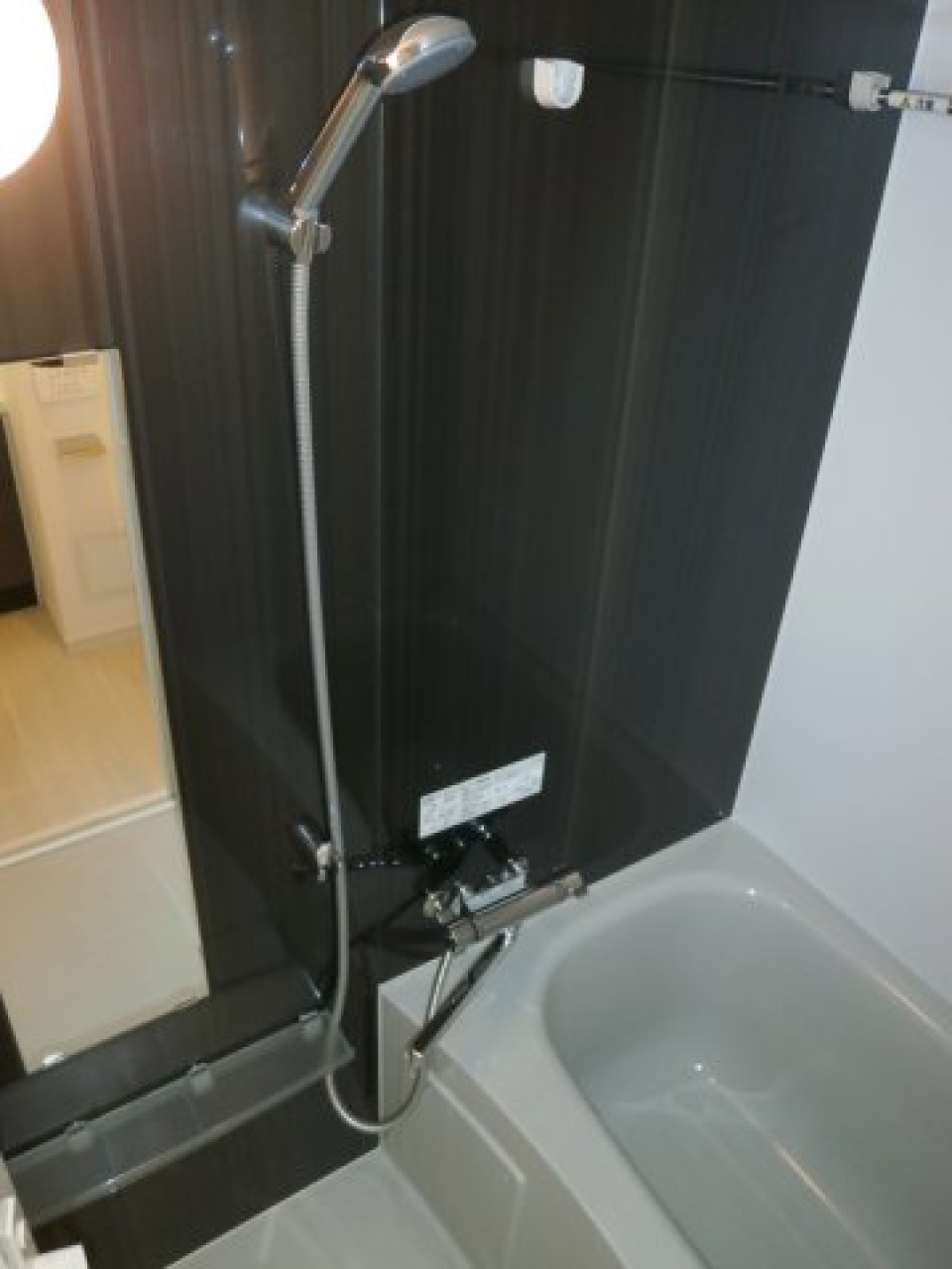 ダークトーンのパネルが導入された落ち着いた浴室です。