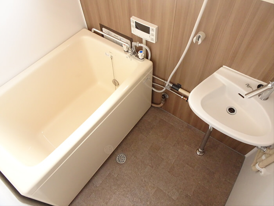 浴室と洗面台はお隣同士。ナチュラルな木目調のパネルが使われています。