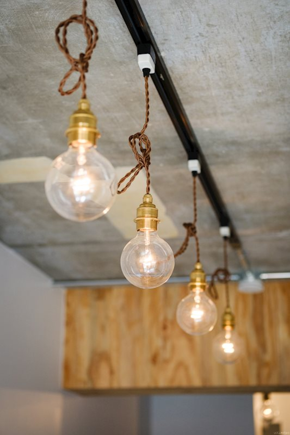 コンクリートの天井についたライティングレールに、裸電球のライトがいい雰囲気。