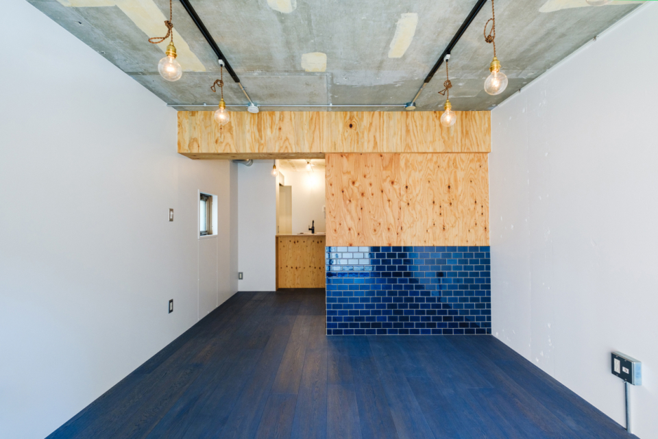 剥き出しのコンクリートと木、群青色のタイルと床のコントラストに心惹かれる。