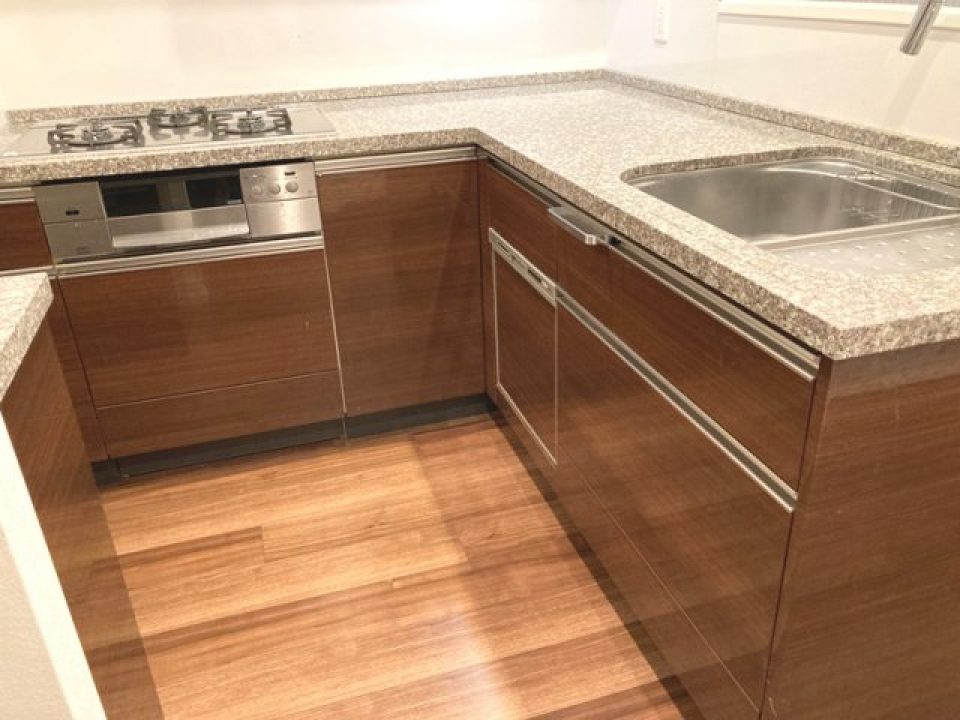 L字型キッチンには茶色いパネルが導入されています。
