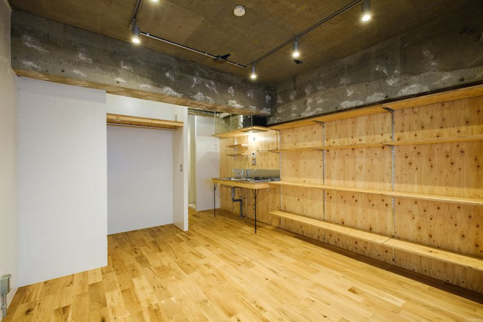 ワイルドな躯体現しの天井、床のオーク材、壁一面のカスタムウォールのラーチ合板と、素材の組み合わせにクリエイター心がくすぐられる空間。