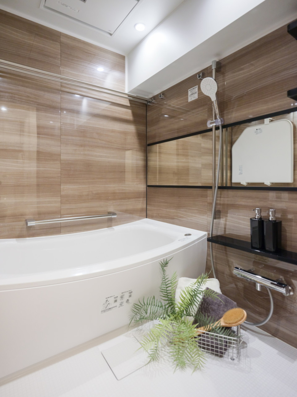 光沢感のある木目の壁とアーチの効いた浴槽が素敵な浴室