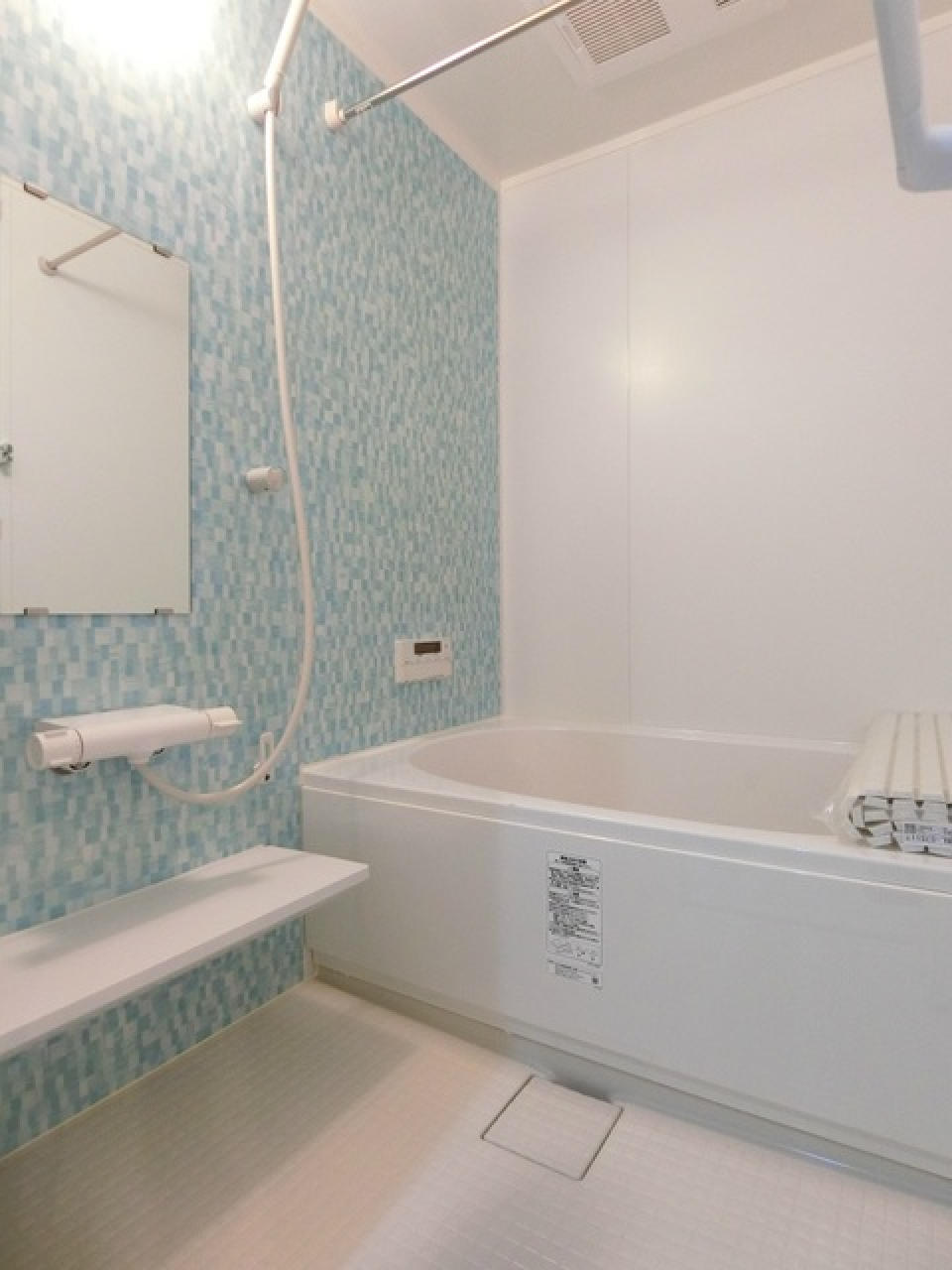 ミントグリーン色のパネルが爽やかな浴室。