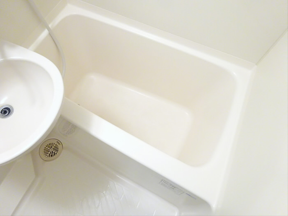 白くシンプルな浴槽と洗面台です。