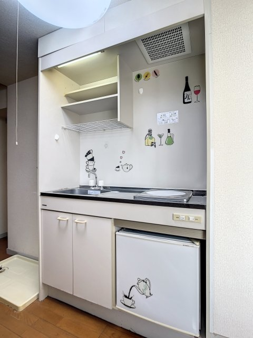 キッチンにはミニ冷蔵庫が設置されており、かわいいステッカーで彩られています。