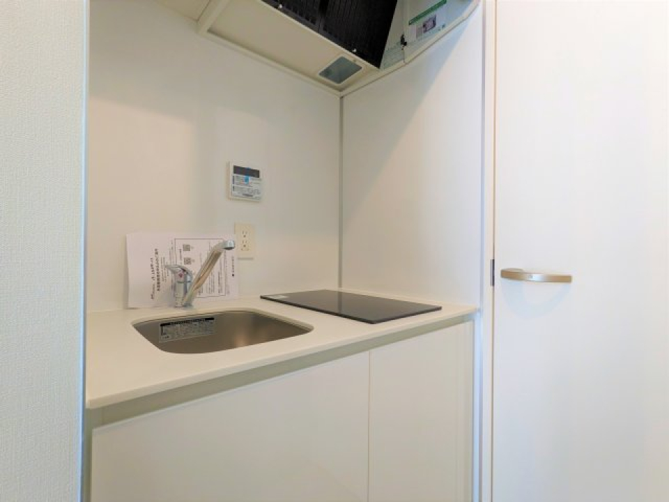 白いパネルのキッチンには２口のIHコンロが設置されています。