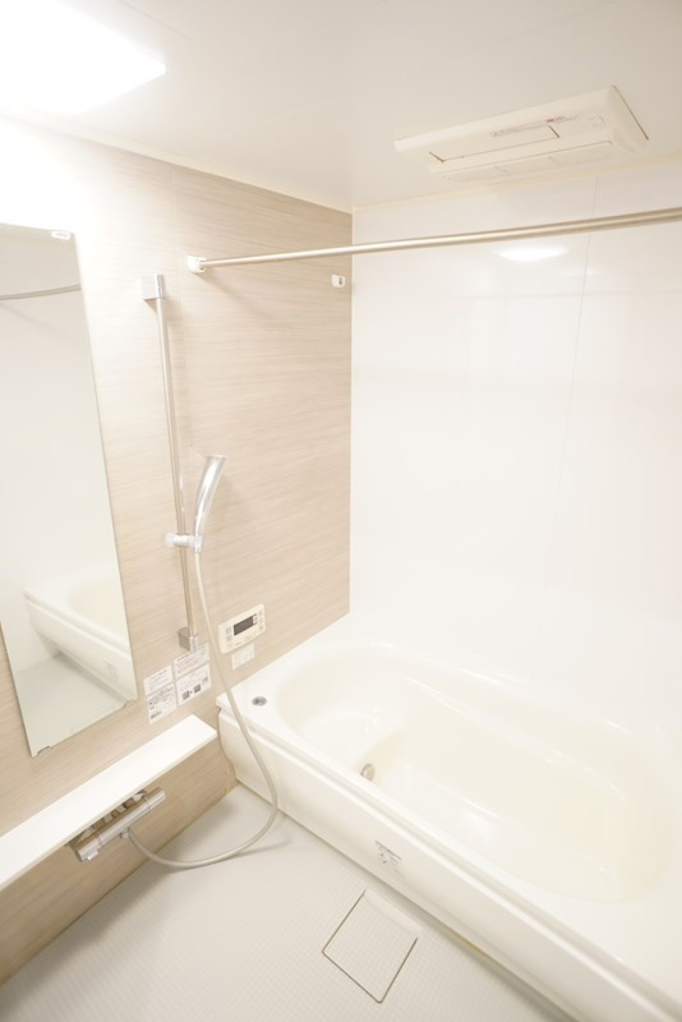大きな鏡のついた真っ白なお風呂。
シャワーカーテンを付けられる突っ張り棒もあります。物干しざおとしても使えそうですね！