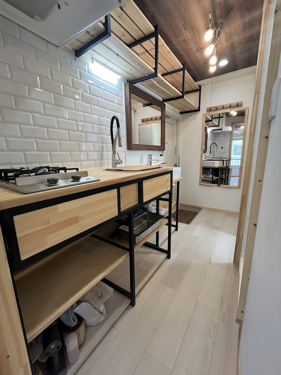 廊下に木とアイアンが素敵なキッチン。白いタイルもかわいい