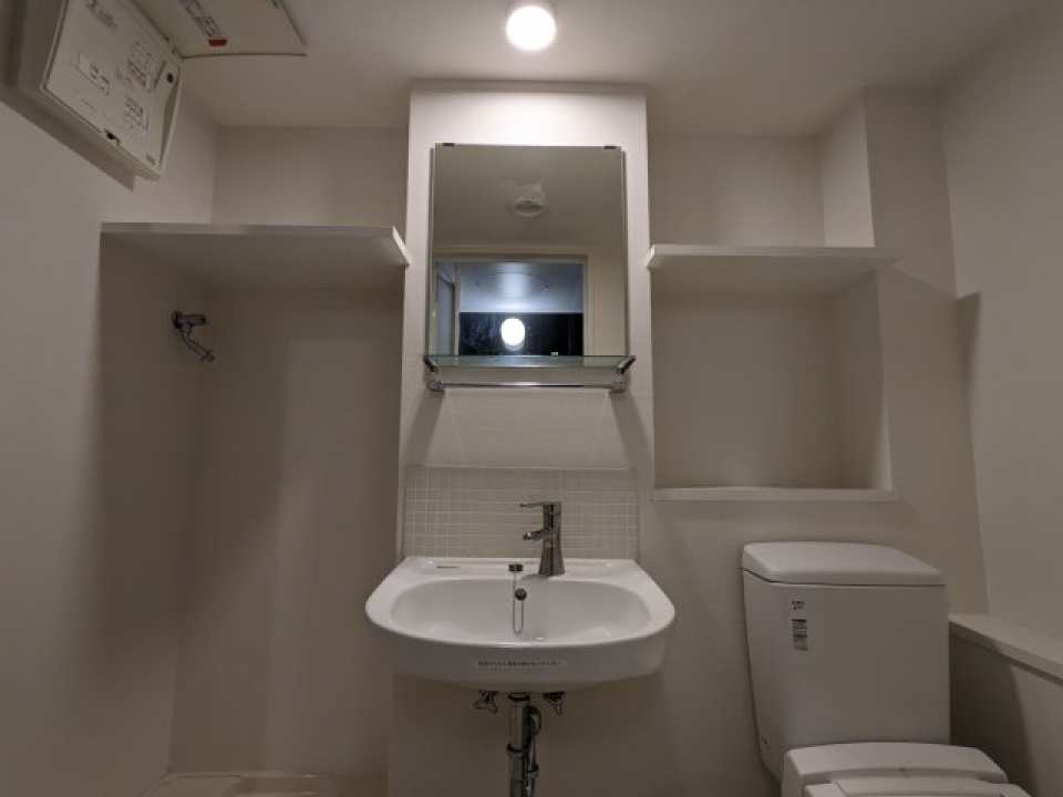 洗面台を中央に、トイレと洗濯機置き場がまとまった水回り。