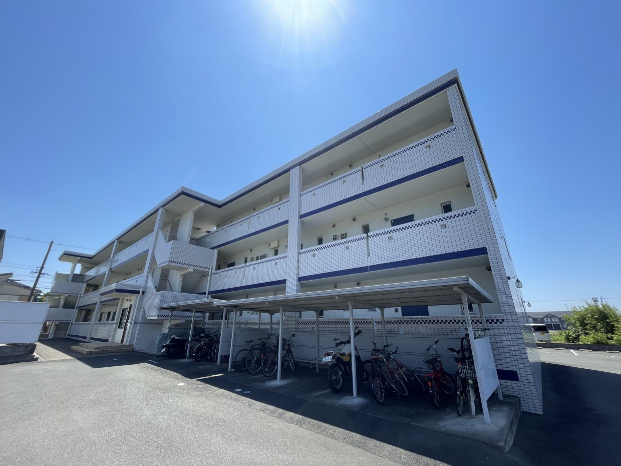 外観。舗装済みの駐車場に屋根付きの駐輪場もあります