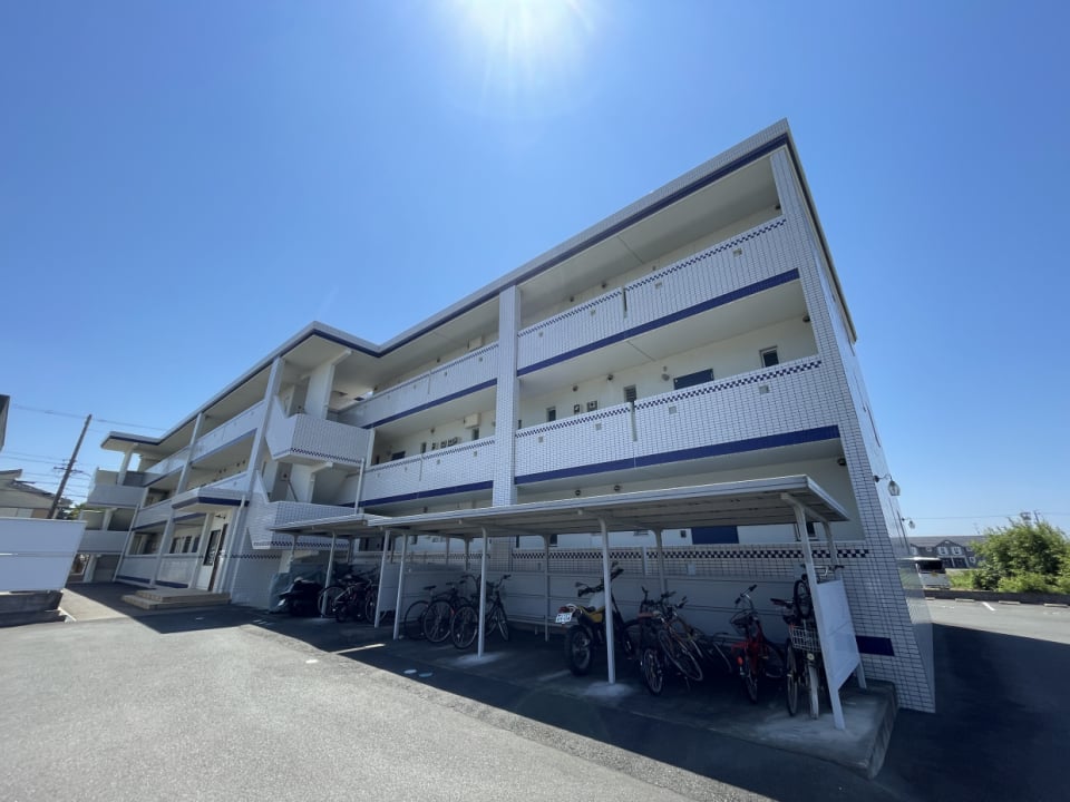 外観。舗装済みの駐車場に屋根付きの駐輪場もあります