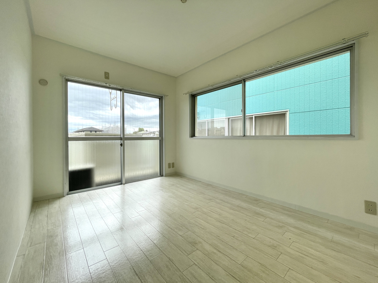 5.5帖の洋室。2面に窓がありますが、東側はすぐ横が建物です