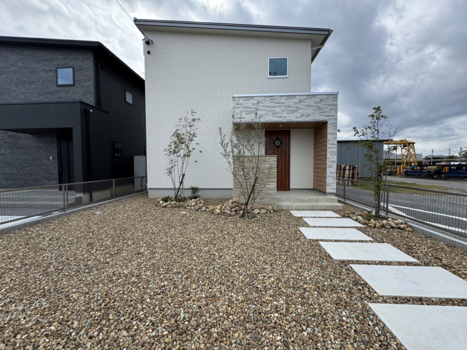 駐車場はブラウンロックの砕石が敷き詰められ、通路のみコンクリートのデザイン