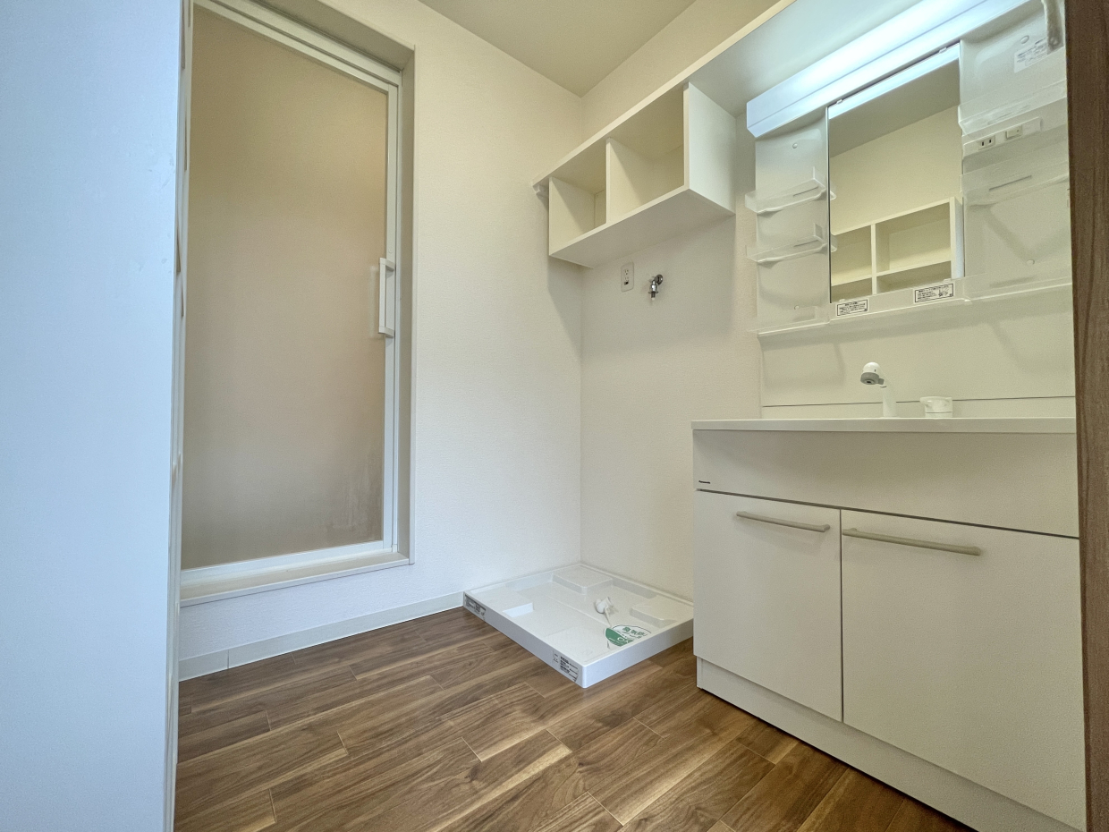 脱衣洗面所。洗濯機置き場の上に備え付けの棚